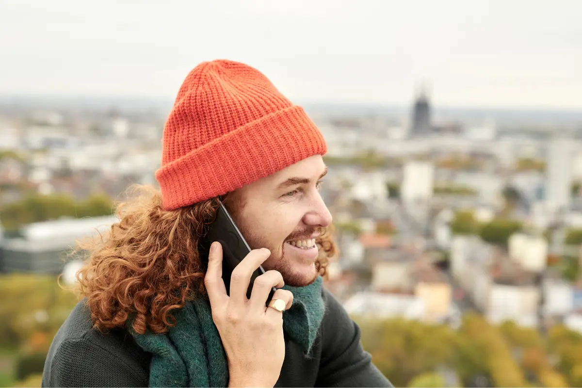 Pipopäinen mies puhuu puhelimessa